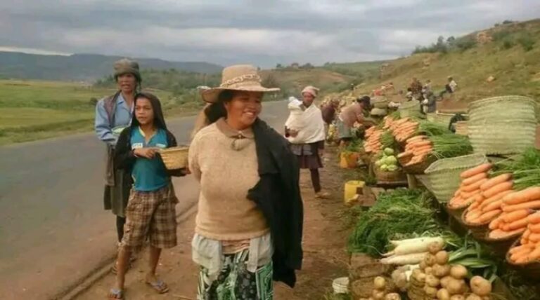Marchande souriante sur un marché des hauts plateaux de Madagascar, symbole de l'accueil et du fihavanana